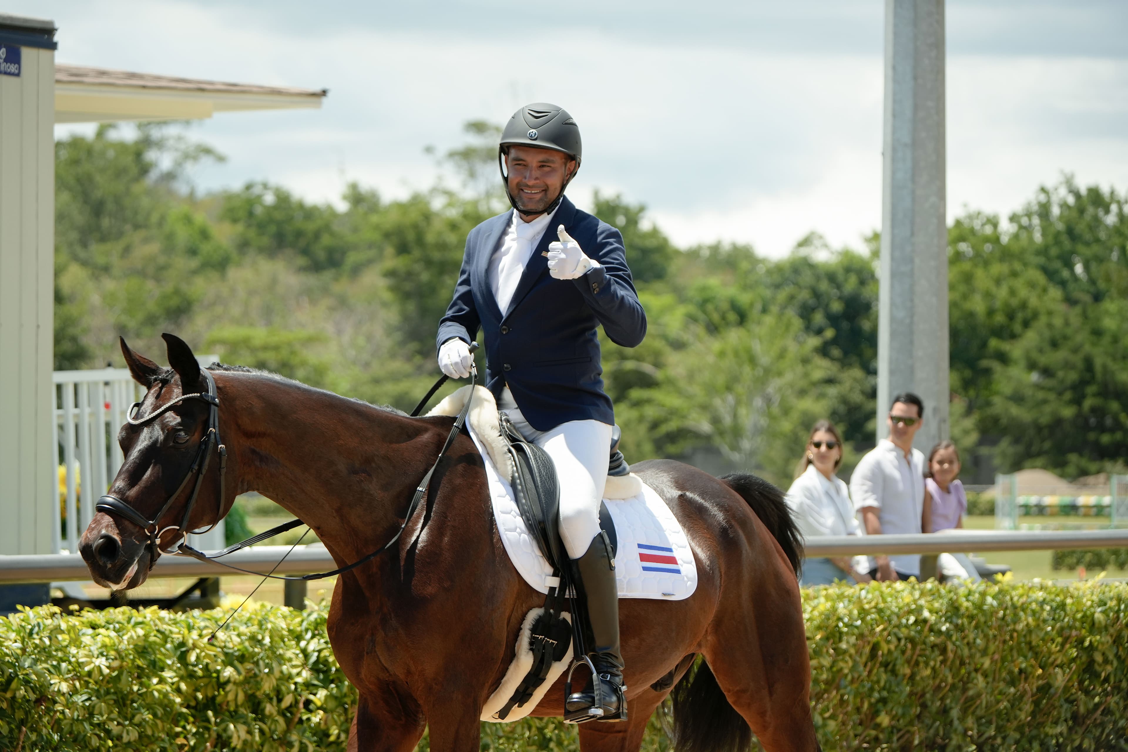 Rider on horseback giving thumbs up at the equestrian arena